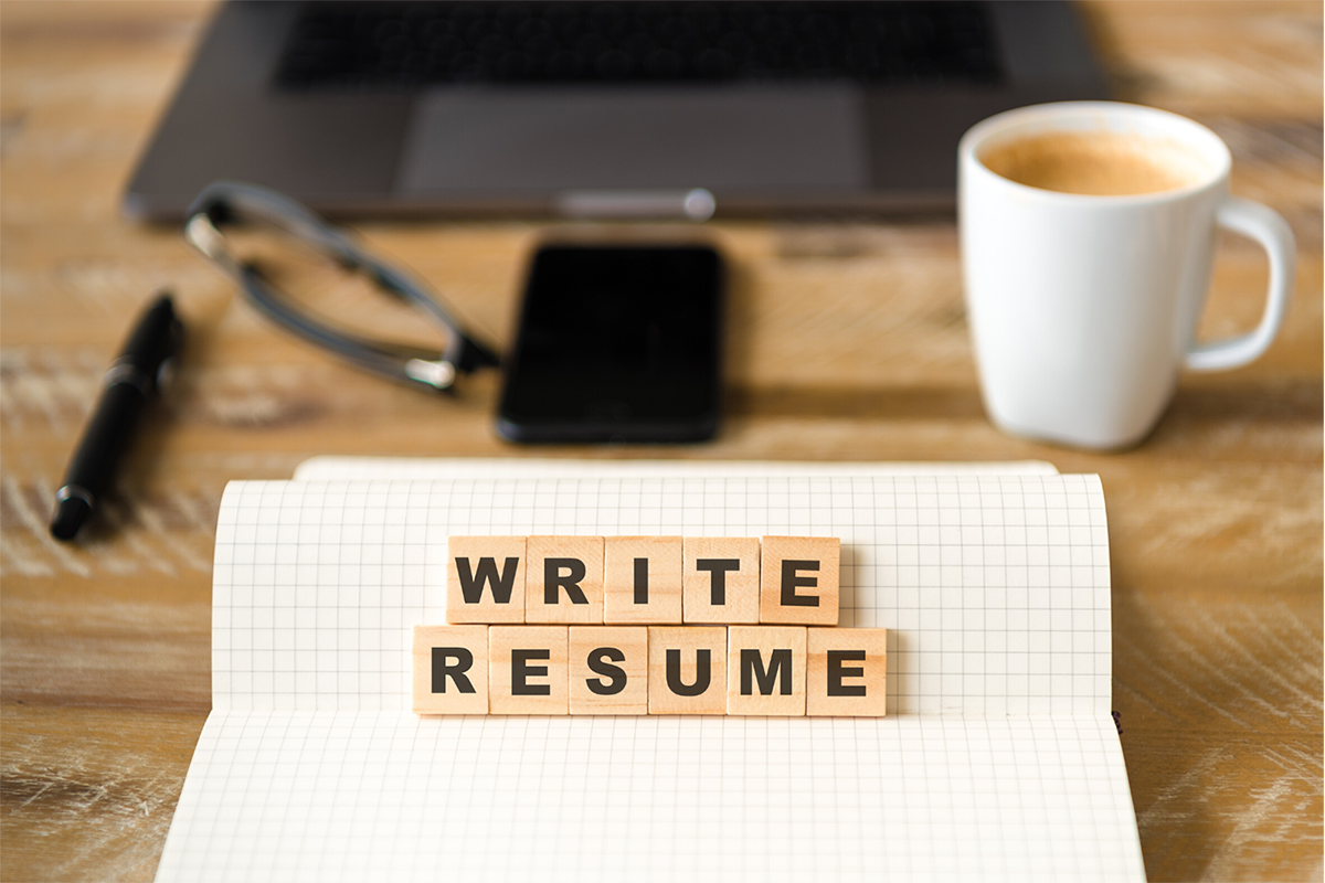 Desktop with "write resume" block on top of grid paper